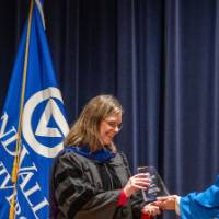 Provost Mili presents glass trophy award to woman